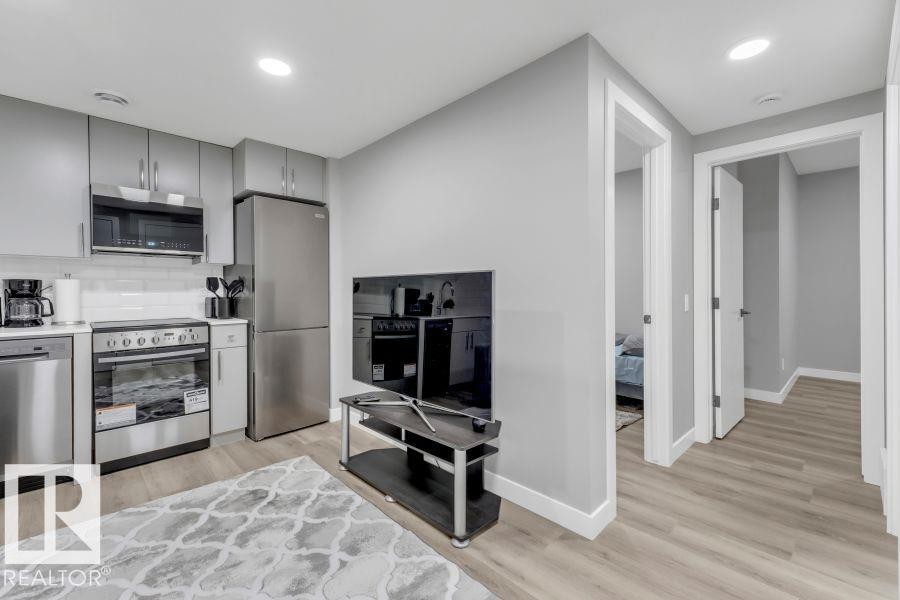 Compact kitchen with stainless steel appliances, grey cabinetry, and white subway tile backsplash - 2415 194 Street Nw, Edmonton, AB