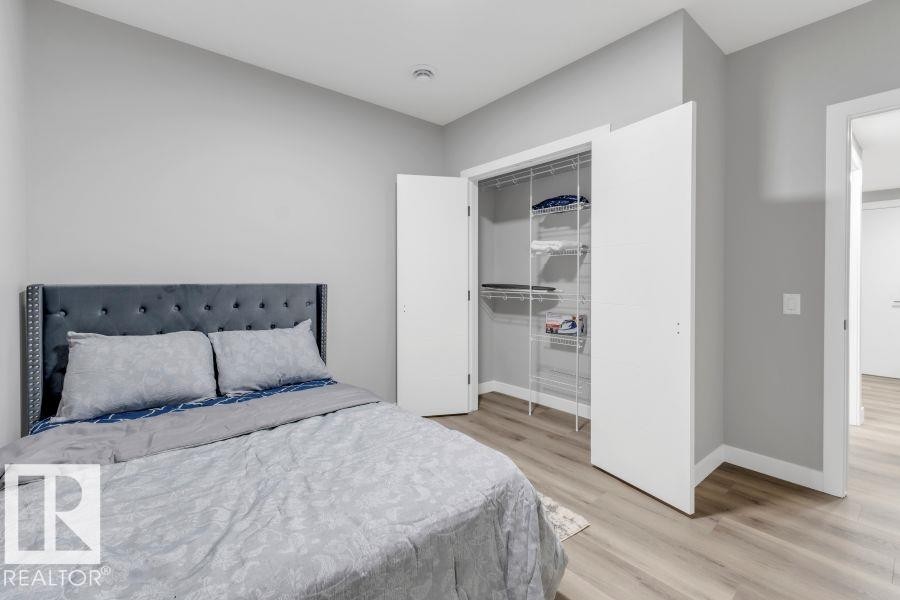 Wood-finish flooring, white walls, and a built-in closet with wire shelving - 2415 194 Street Nw, Edmonton, AB