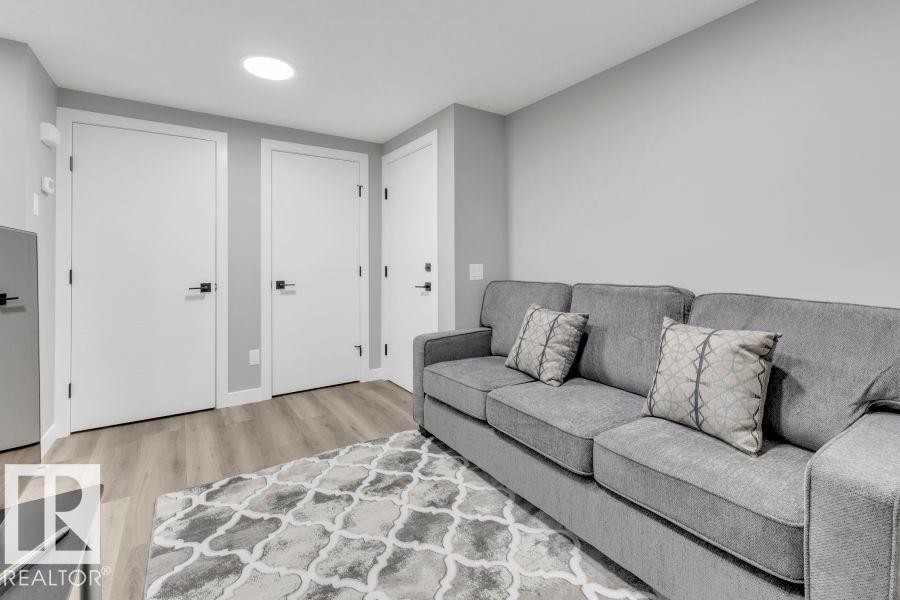 Recessed ceiling lighting, light gray wall finishes, wood-finish flooring, white doors with black hardware - 2415 194 Street Nw, Edmonton, AB