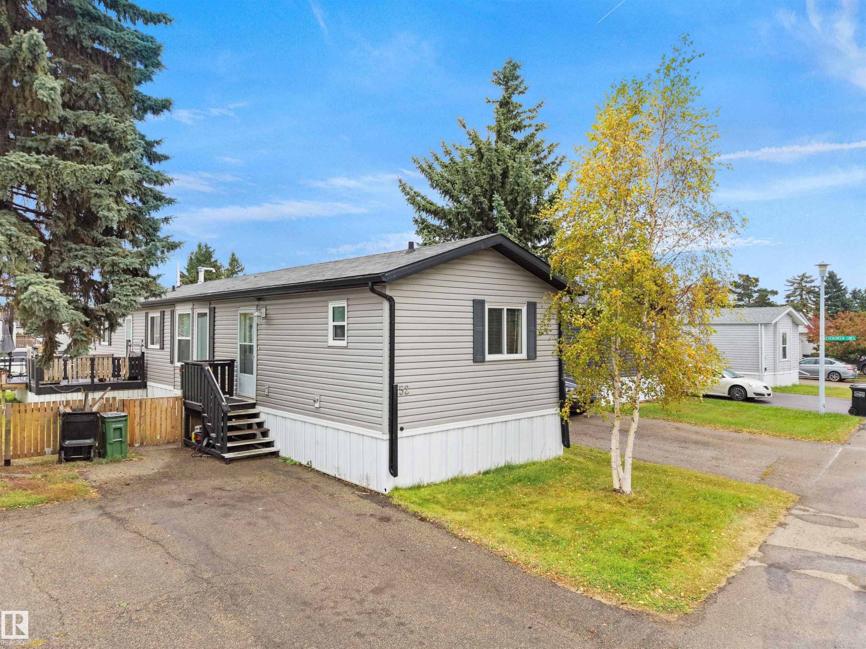 Light gray siding exterior with dark shutters, dark trim, and a dark shingled roof - 52 Evergreen Park Northwest, Edmonton, AB