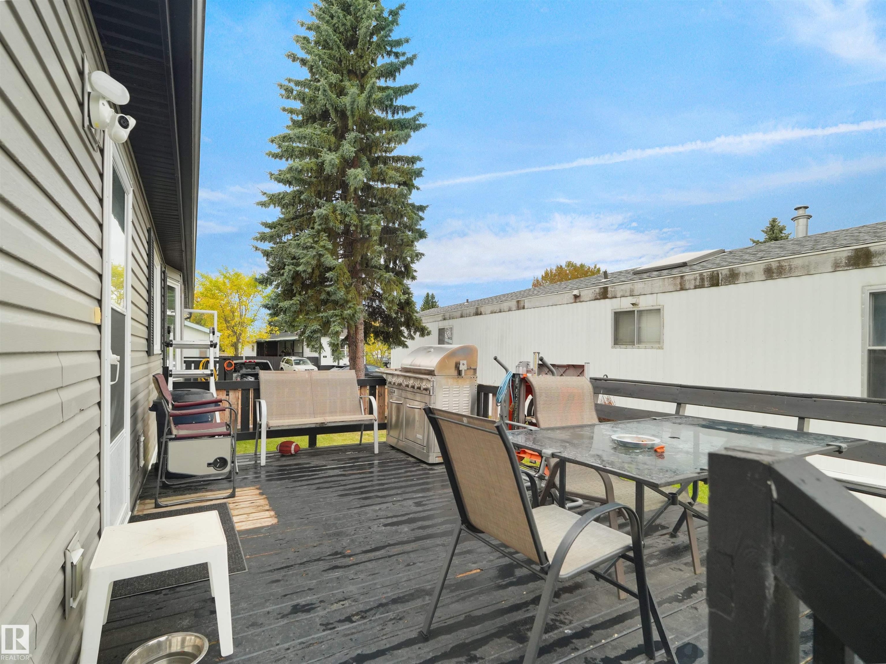 Expansive outdoor deck featuring dark wood-finish planking, a privacy railing, and direct exterior access - 52 Evergreen Park Northwest, Edmonton, AB