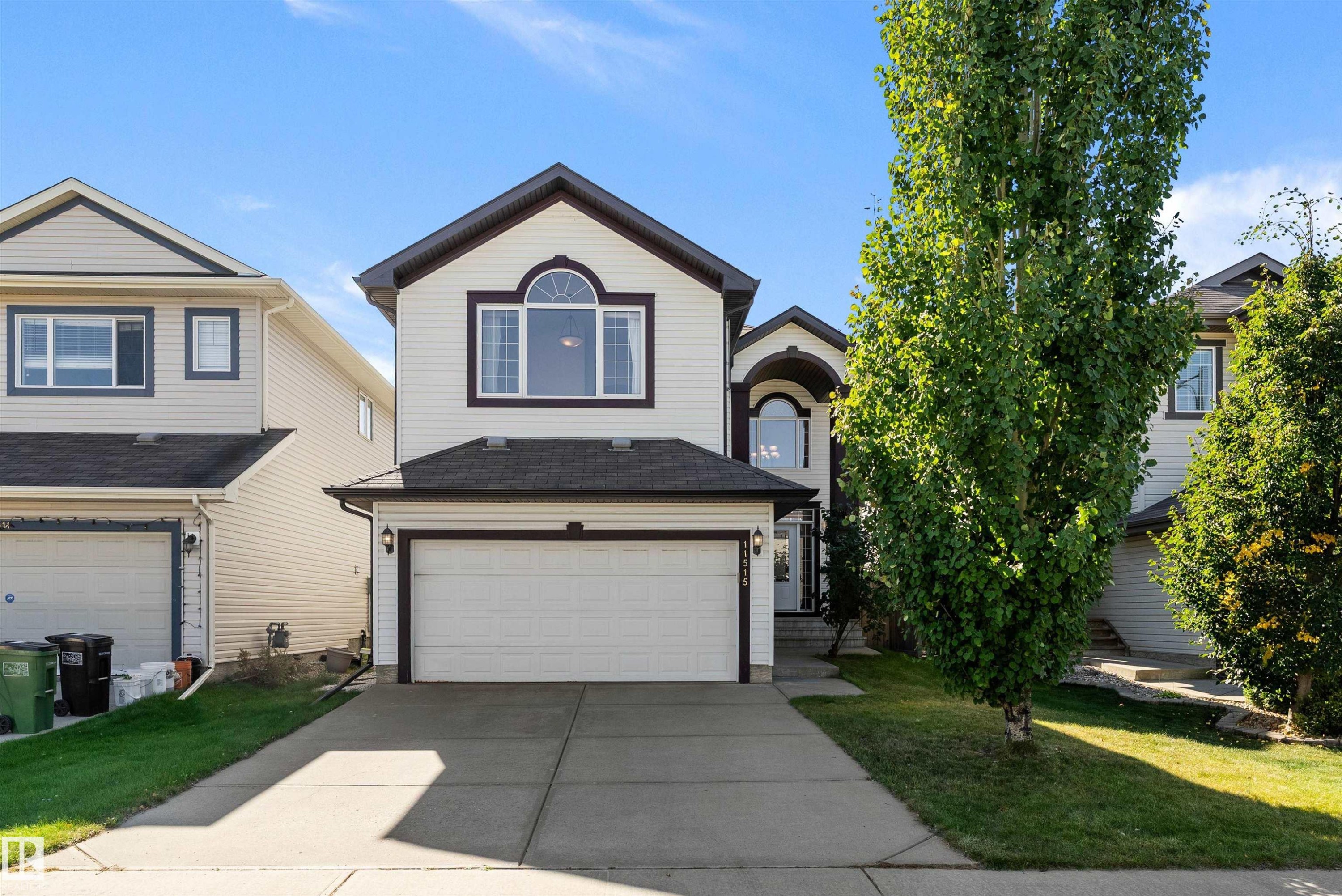 Exterior featuring a two-car garage, concrete driveway, and mature landscaping - 11515 16 Avenue Sw, Edmonton, AB
