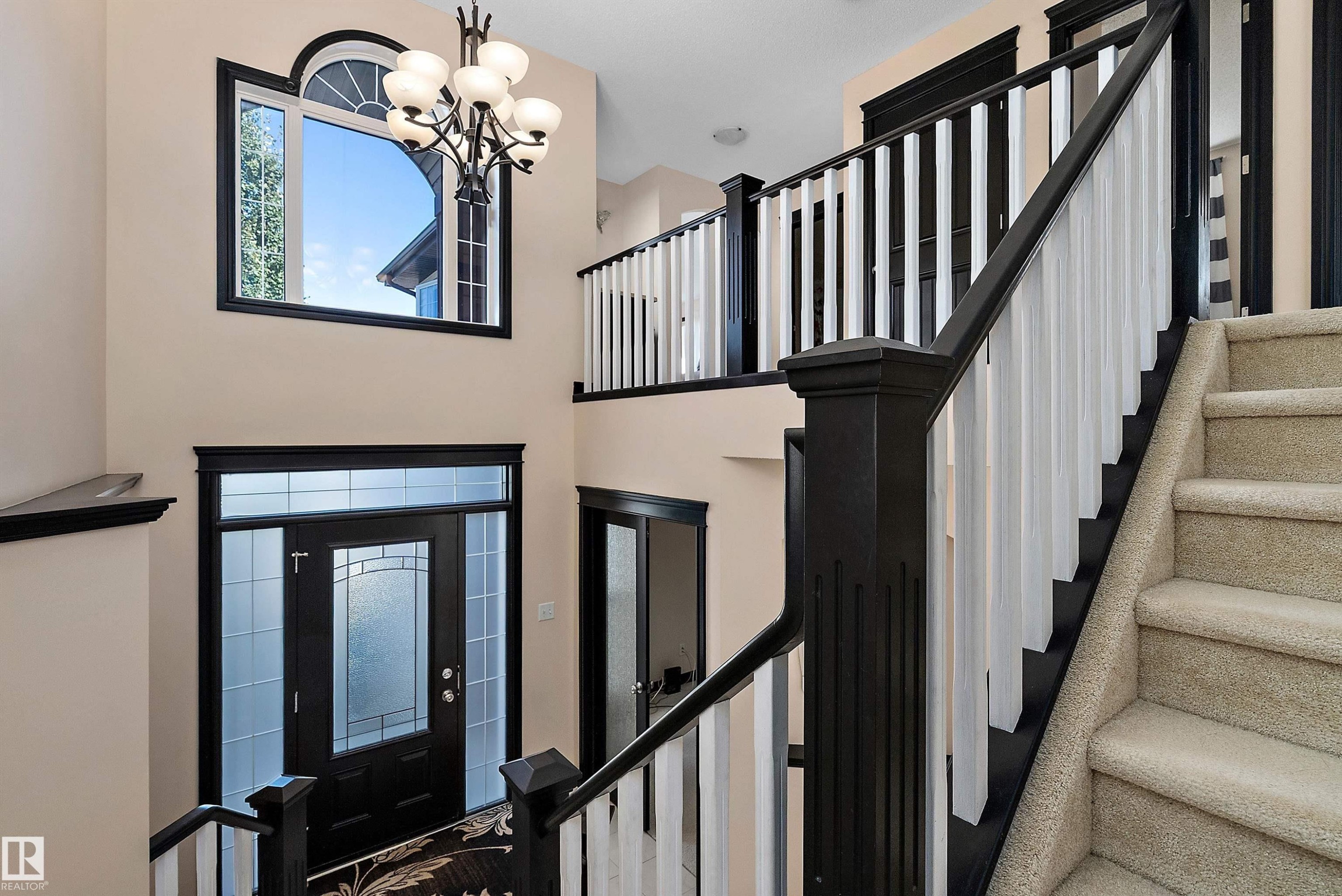 Two-story foyer with a decorative front entry door, transom window, and an arched window - 11515 16 Avenue Sw, Edmonton, AB