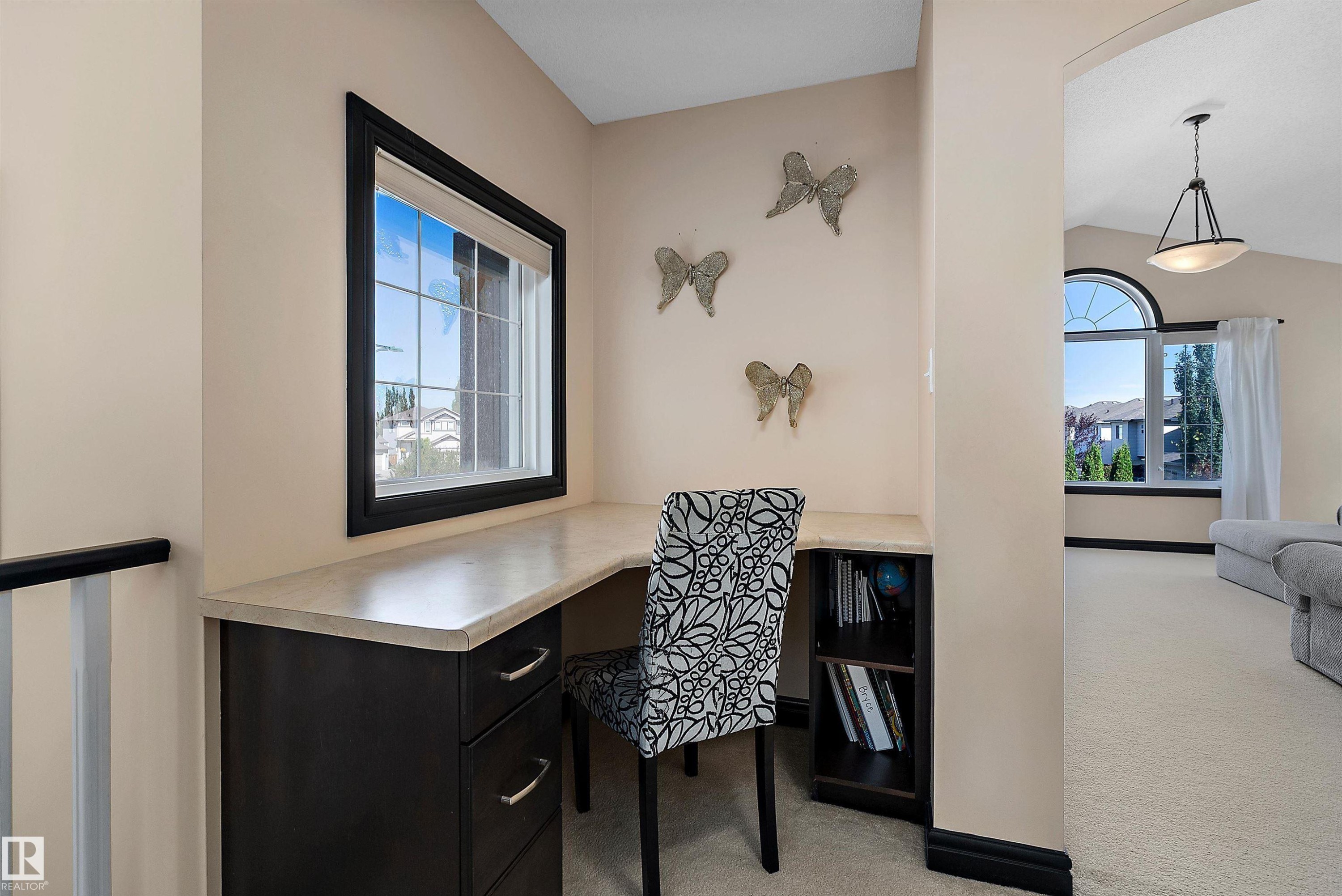 Built-in desk with a light-colored countertop and dark wood-finish cabinetry - 11515 16 Avenue Sw, Edmonton, AB