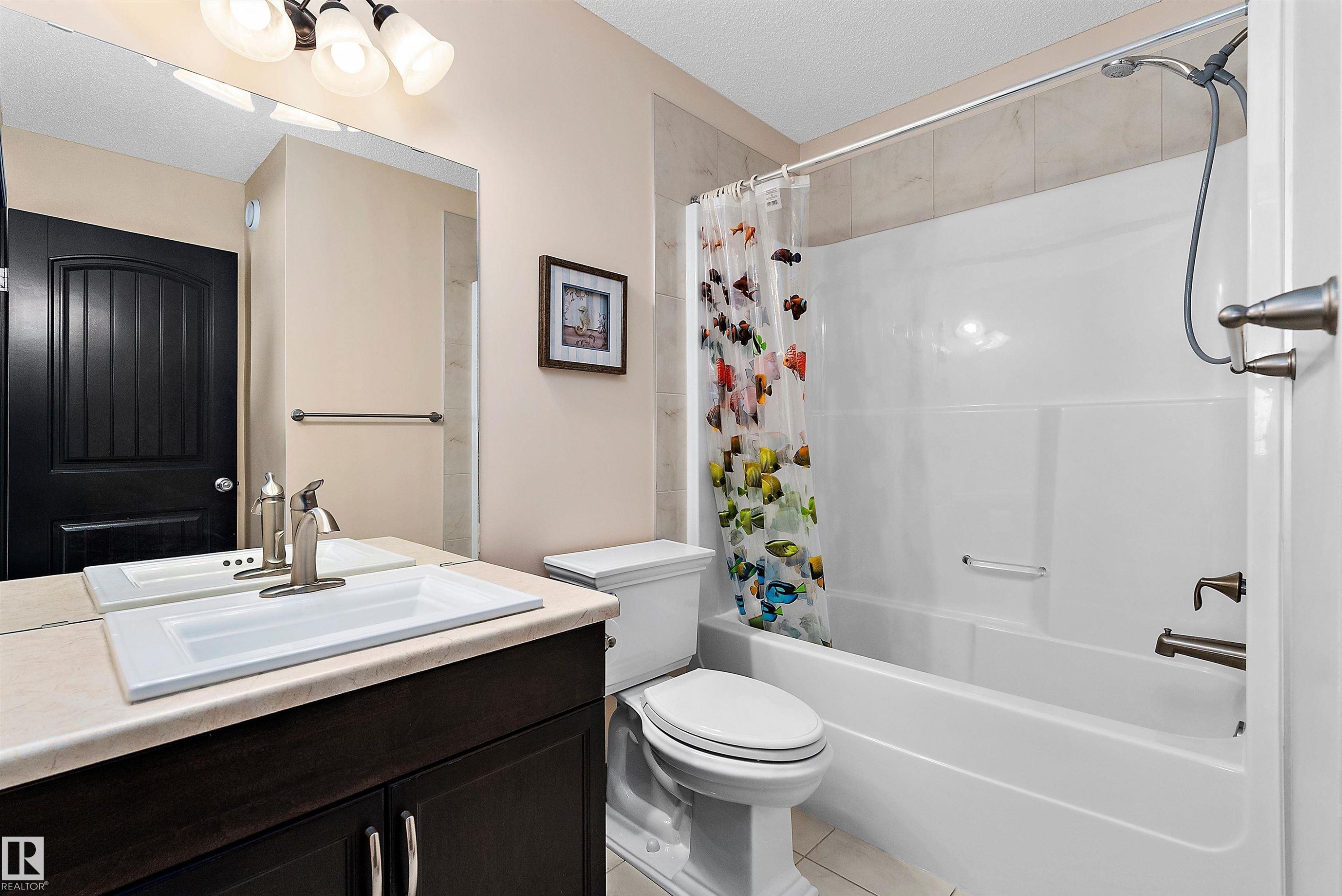 Vanity with an integrated rectangular sink, brushed nickel faucet, and under-cabinet storage - 11515 16 Avenue Sw, Edmonton, AB