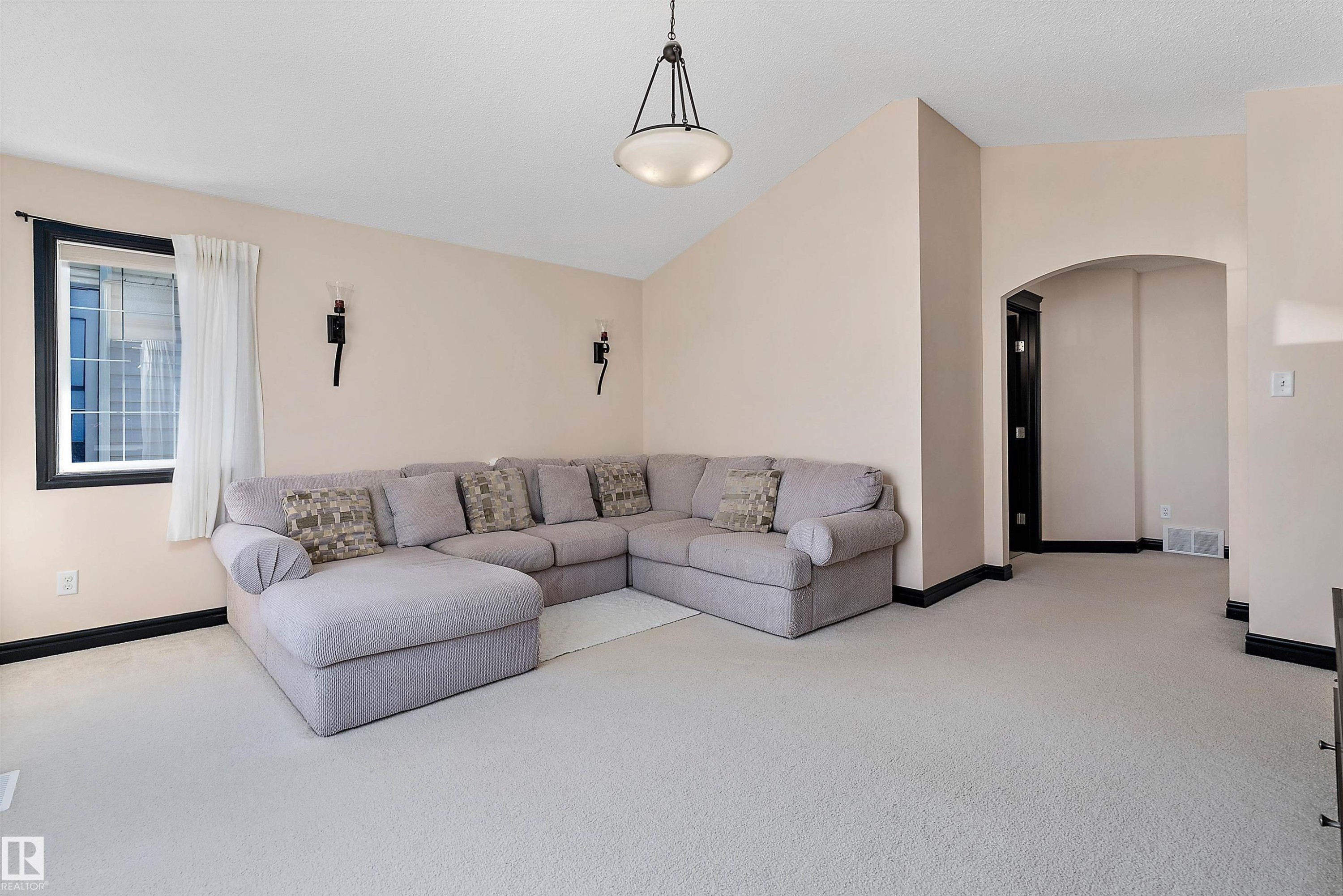 Light-toned wall paint, arched doorway, black baseboards, and a window with black trim - 11515 16 Avenue Sw, Edmonton, AB