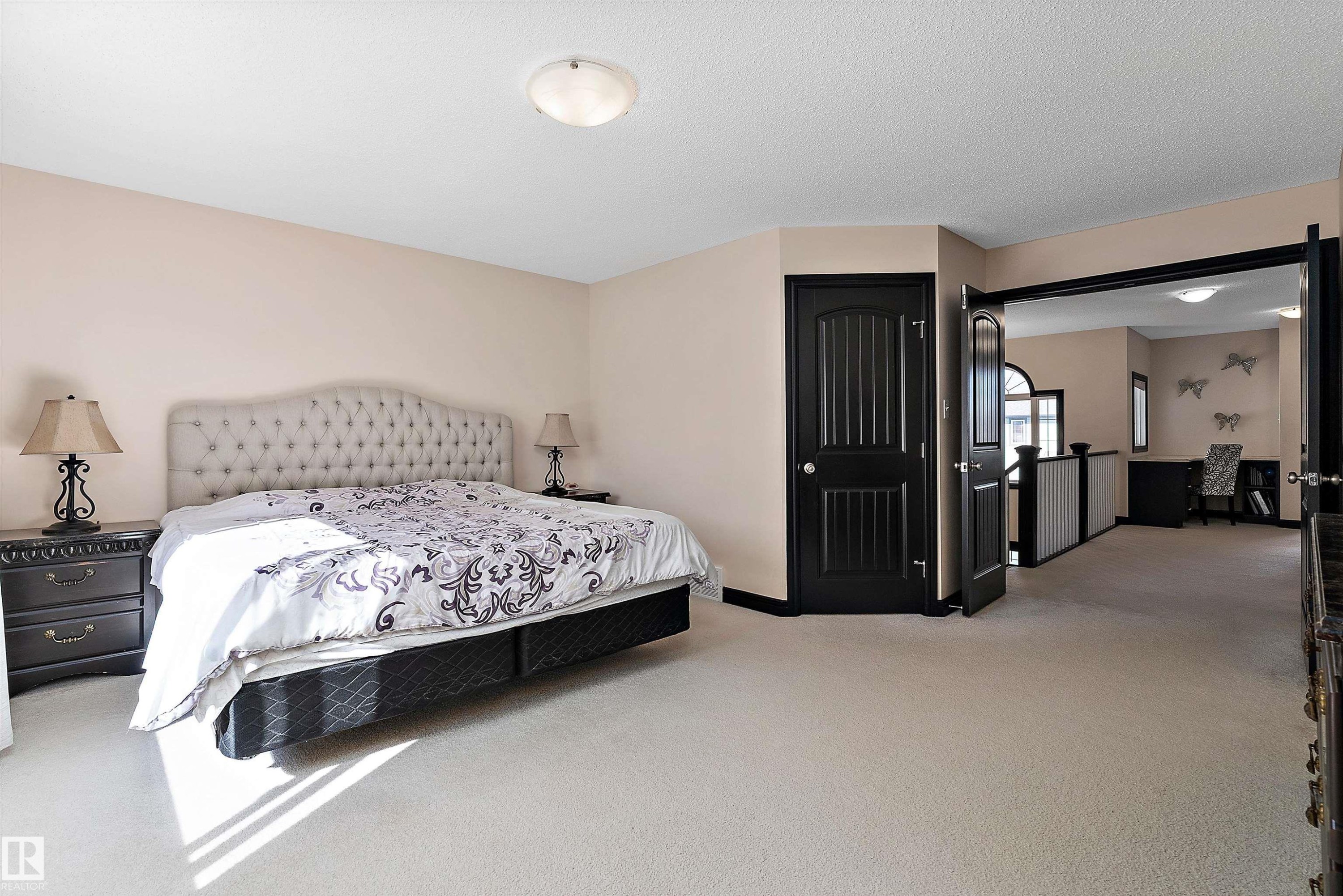 Neutral tone wall paint, light-colored carpet flooring, recessed ceiling light fixture, dark paneled doors, and an open entryway to an additional space - 11515 16 Avenue Sw, Edmonton, AB