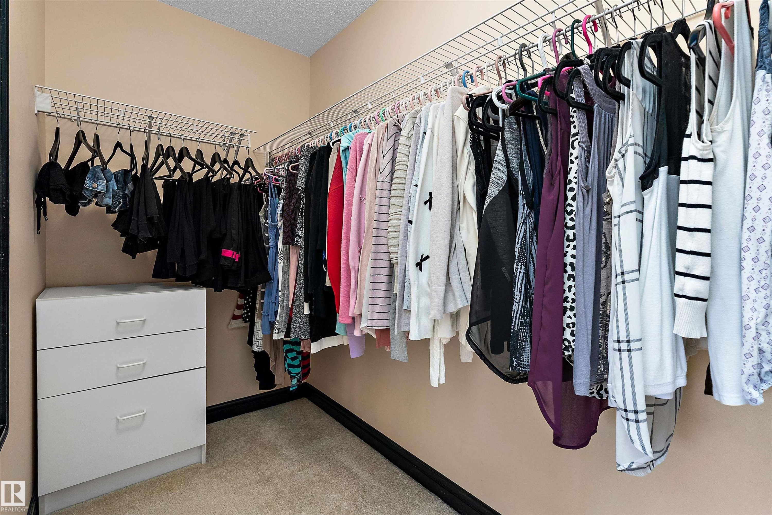 Walk-in closet featuring wire shelving, integrated hanging rods, and built-in drawers - 11515 16 Avenue Sw, Edmonton, AB