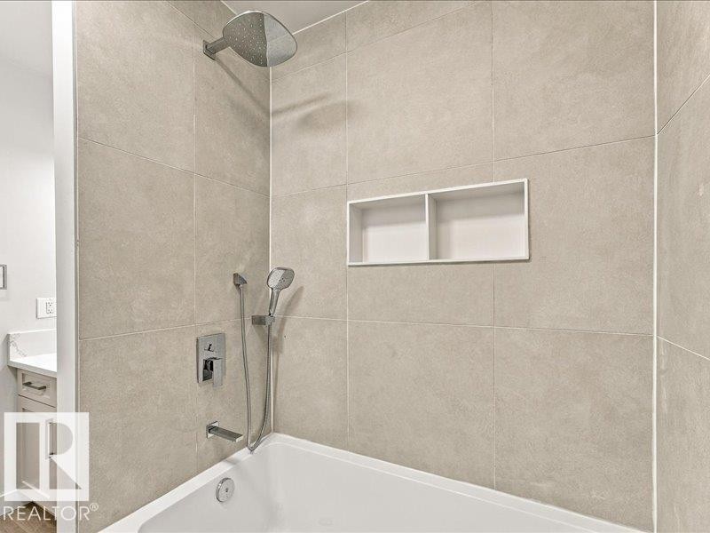 Wall-mounted shower head, integrated shower niche, handheld shower fixture, and a built-in bathtub - 18325 66 Avenue Nw, Edmonton, AB
