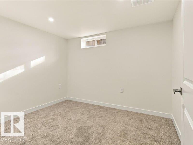 Recessed lighting, neutral wall paint, light-colored carpeting, and a small transom window - 18325 66 Avenue Nw, Edmonton, AB