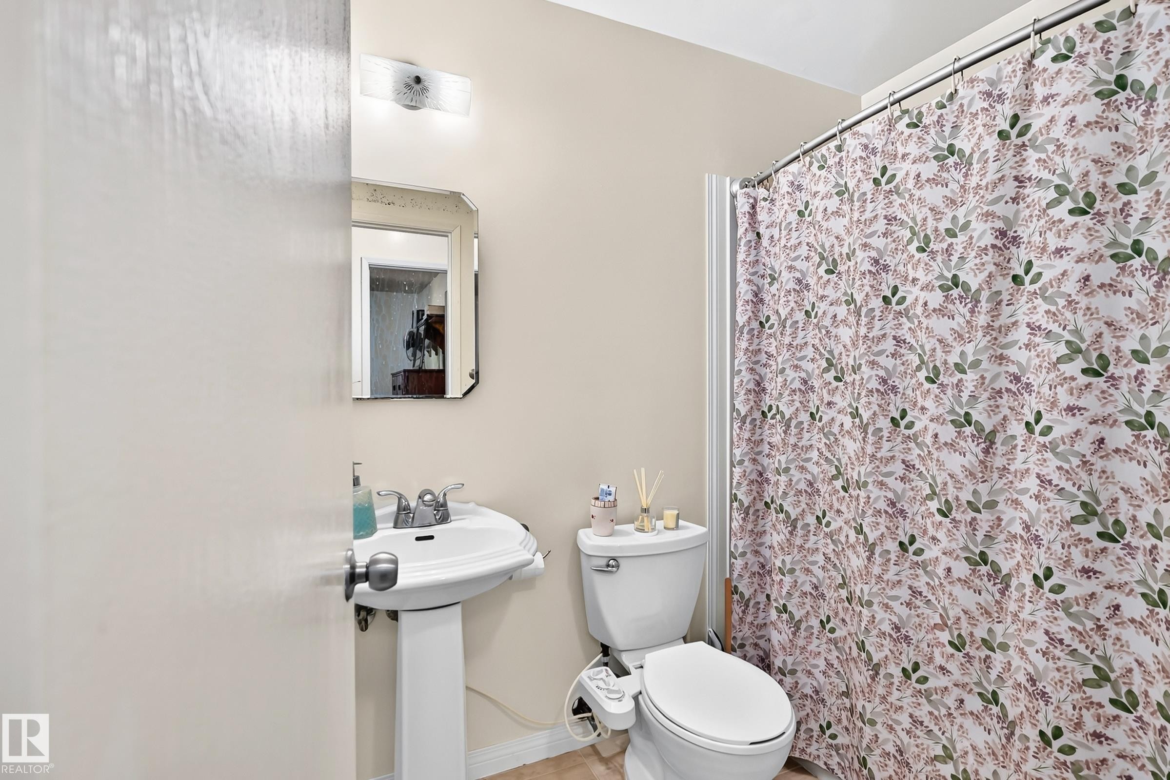 Pedestal sink with chrome fixtures, an overhead vanity light, and a wall-mounted mirror - 11007 173A Avenue Nw, Edmonton, AB