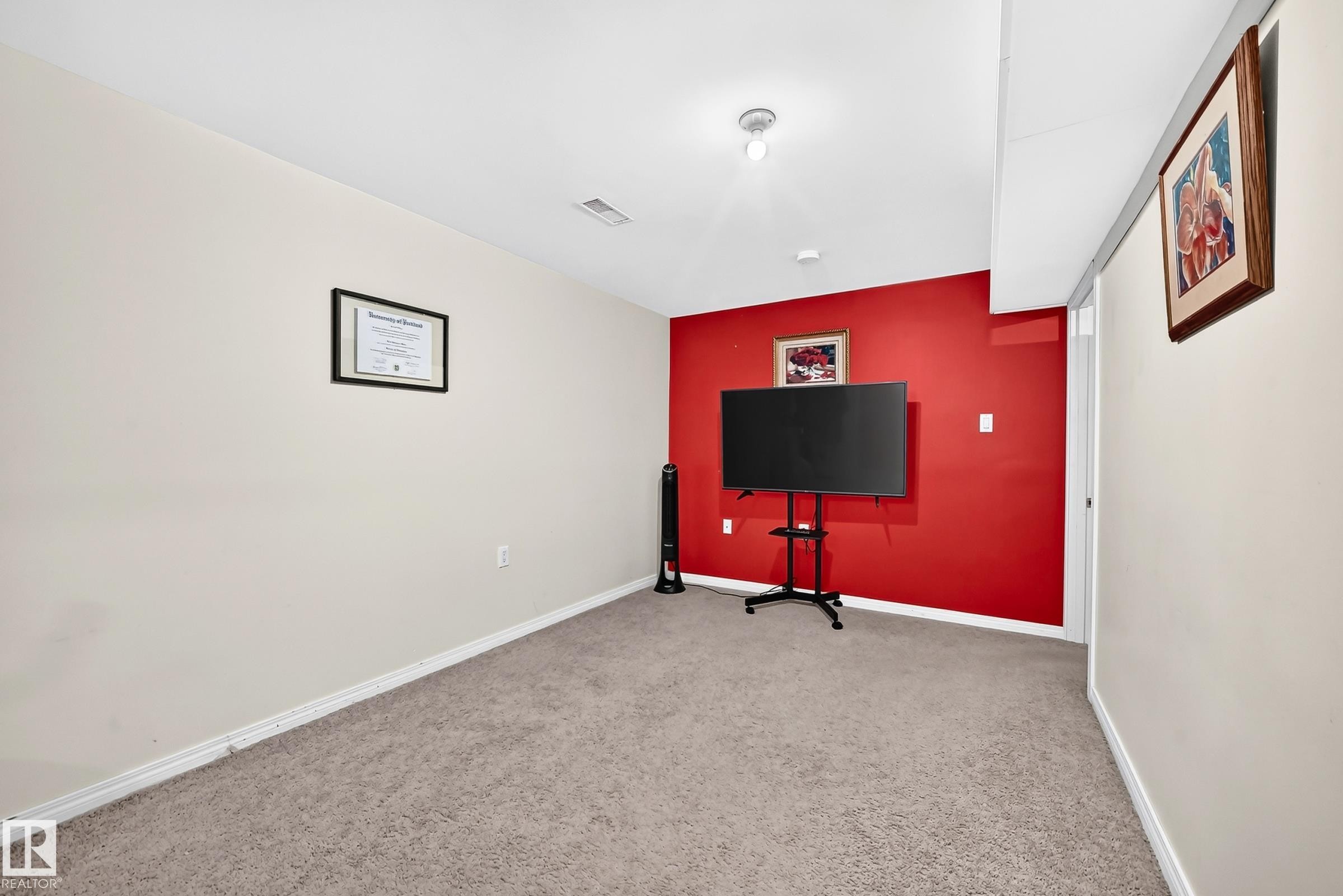 Carpeted flooring, white trim, and a prominent red accent wall - 11007 173A Avenue Nw, Edmonton, AB