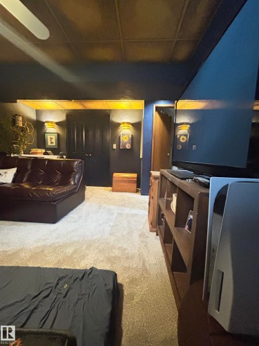Recessed ceiling with acoustic tiles, wall-mounted sconce lighting, and wood-finish built-in shelving - 10678 Beaumaris Road Nw, Edmonton, AB 