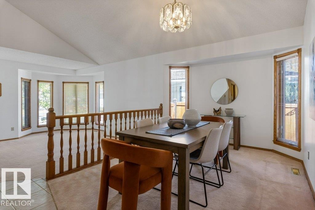 Vaulted ceiling, open railing, bay window, wood-trim windows, and a decorative light fixture - 507 Burton Close Nw, Edmonton, AB