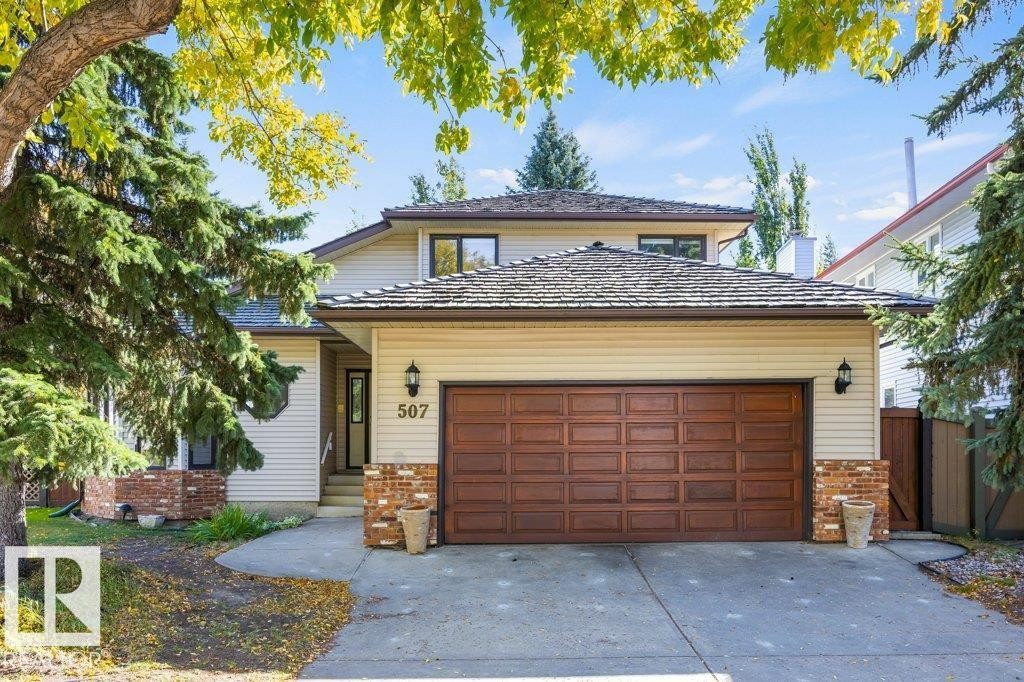 Two-story residence featuring light-colored siding and brick accents - 507 Burton Close Nw, Edmonton, AB