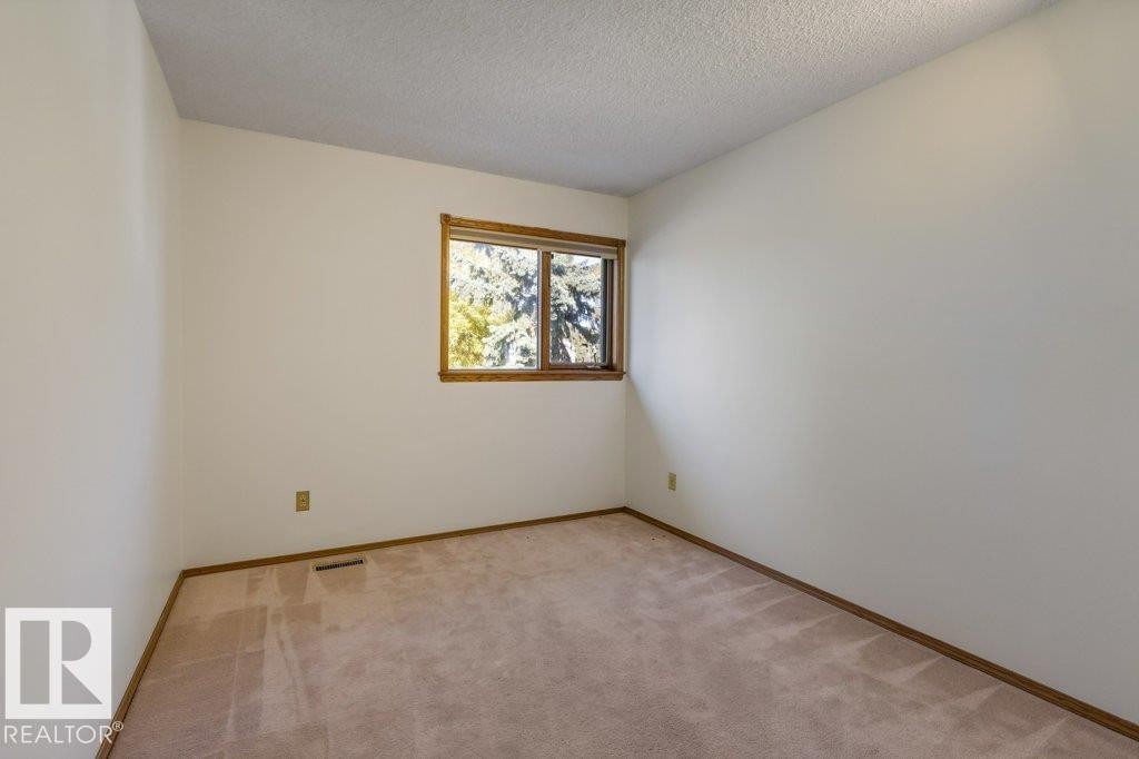 Room with neutral wall color, light-toned carpeting, and a window with wood trim - 507 Burton Close Nw, Edmonton, AB