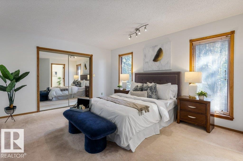 Mirrored sliding closet doors, wood-trimmed windows, track lighting, and soft carpeting - 507 Burton Close Nw, Edmonton, AB