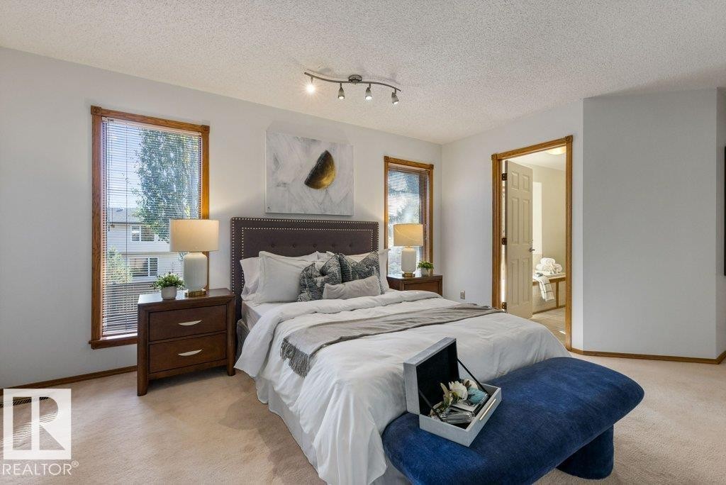 Carpeted flooring throughout, track lighting fixture, wood-trimmed windows with blinds, and a doorway leading to another room - 507 Burton Close Nw, Edmonton, AB