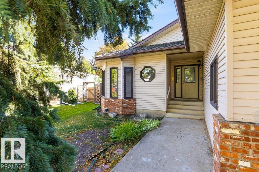 Siding exterior with brick accents, bay window, octagon window, concrete walkway, and landscaped grounds - 507 Burton Close Nw, Edmonton, AB