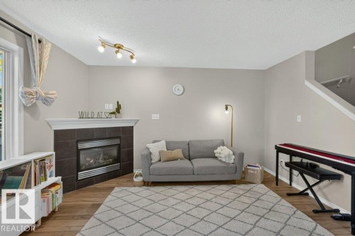 Corner fireplace with dark tile surround and white mantel - #41 287 Macewan Rd Sw, Edmonton, AB 