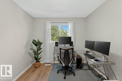 Neutral wall paint, wood-finish flooring, and a window with white trim - #41 287 Macewan Rd Sw, Edmonton, AB 