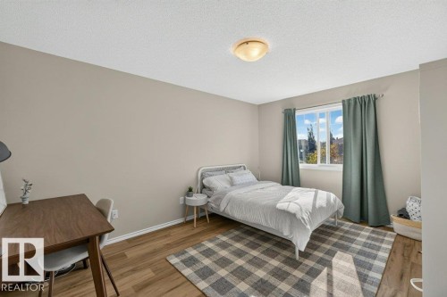 Neutral wall paint, wood-finish flooring, and a window with natural light - #41 287 Macewan Rd Sw, Edmonton, AB 