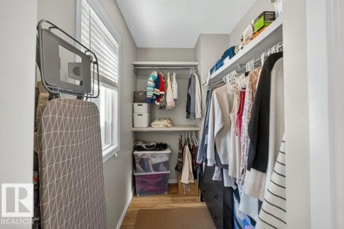 Walk-in closet with window, integrated shelving, and hanging rods - #41 287 Macewan Rd Sw, Edmonton, AB 