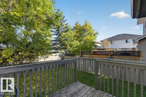 Wood deck with a slatted railing, fenced perimeter, and mature trees - #41 287 Macewan Rd Sw, Edmonton, AB 