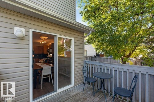 Private wooden deck with a slatted railing, exterior siding, and sliding glass door access - #41 287 Macewan Rd Sw, Edmonton, AB 