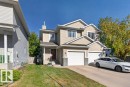 Two-story residence featuring light-toned siding, a two-car garage, and a concrete driveway - #41 287 Macewan Rd Sw, Edmonton, AB 