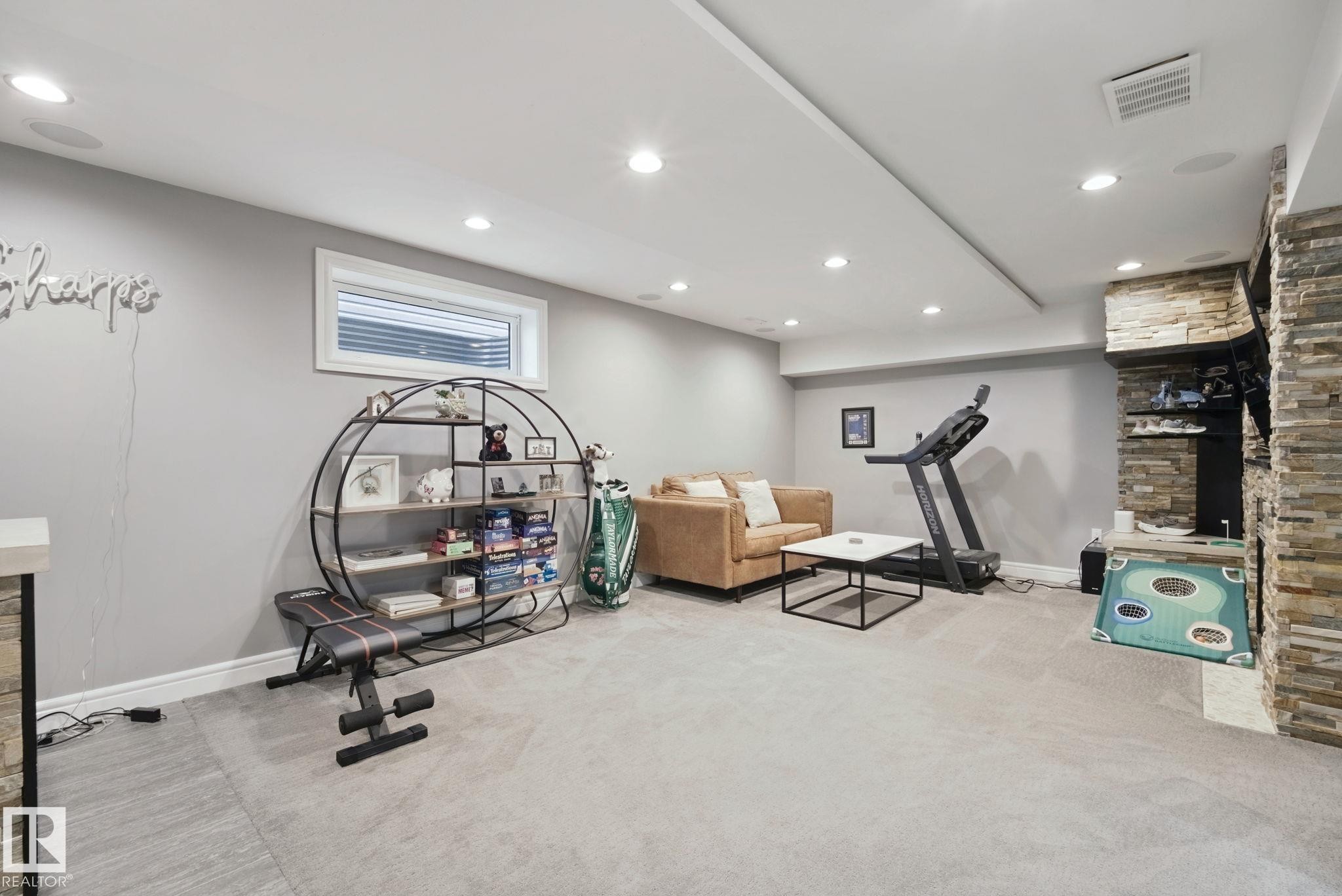 Recessed lighting, light gray carpeting, stone veneer accent wall, and a horizontal window - 324 Ascott Crescent, Sherwood Park, AB