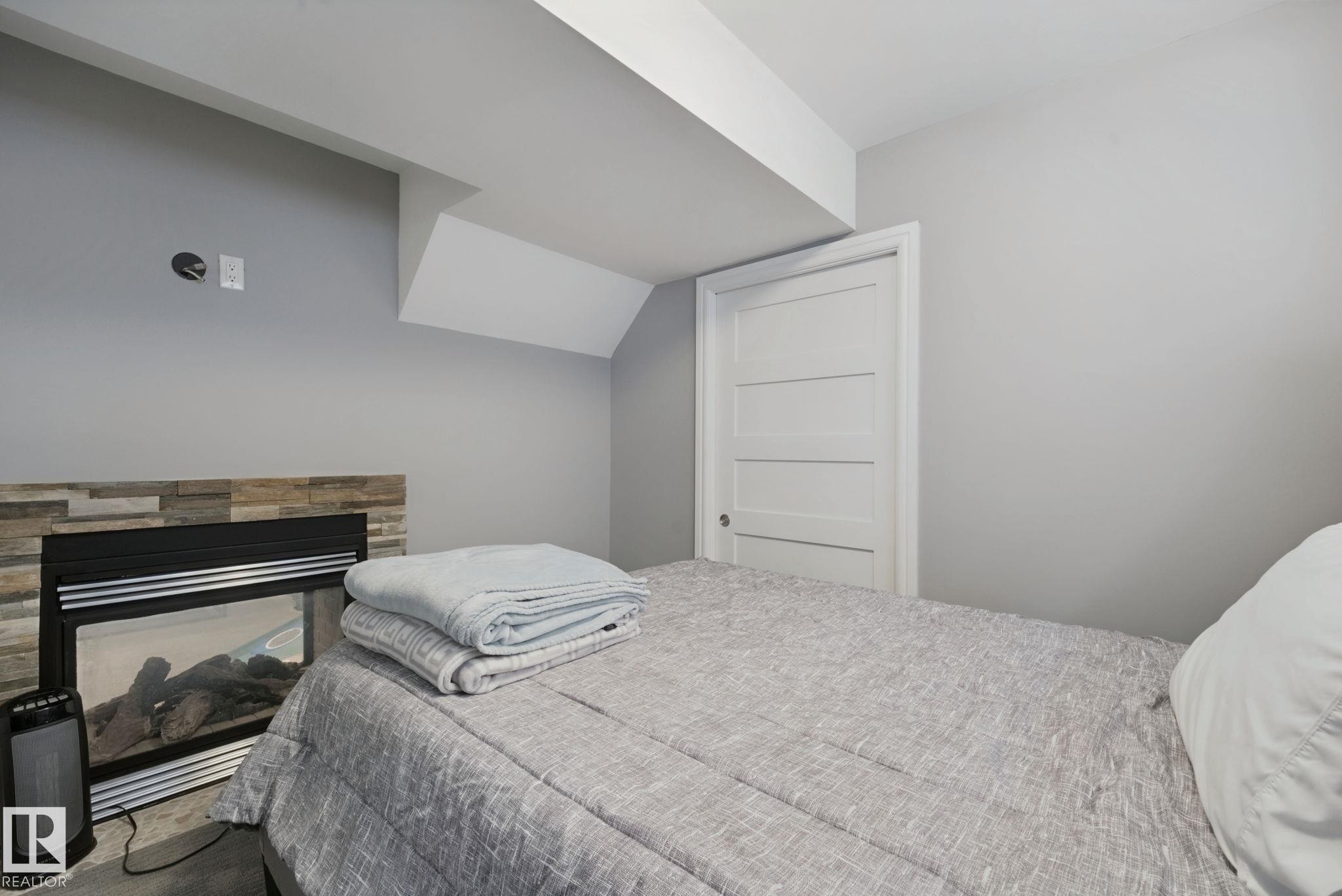 Recessed electric fireplace with stone-finish surround - 324 Ascott Crescent, Sherwood Park, AB