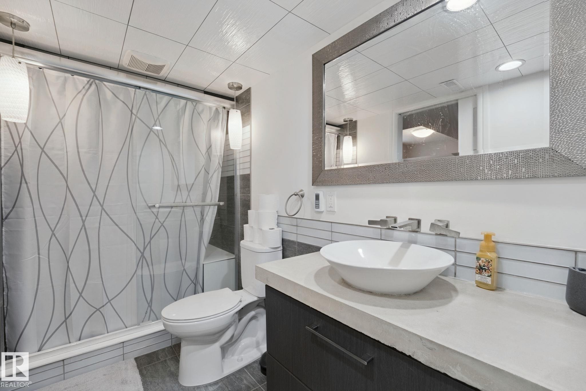 Recessed lighting illuminating a frameless shower with a built-in bench - 324 Ascott Crescent, Sherwood Park, AB