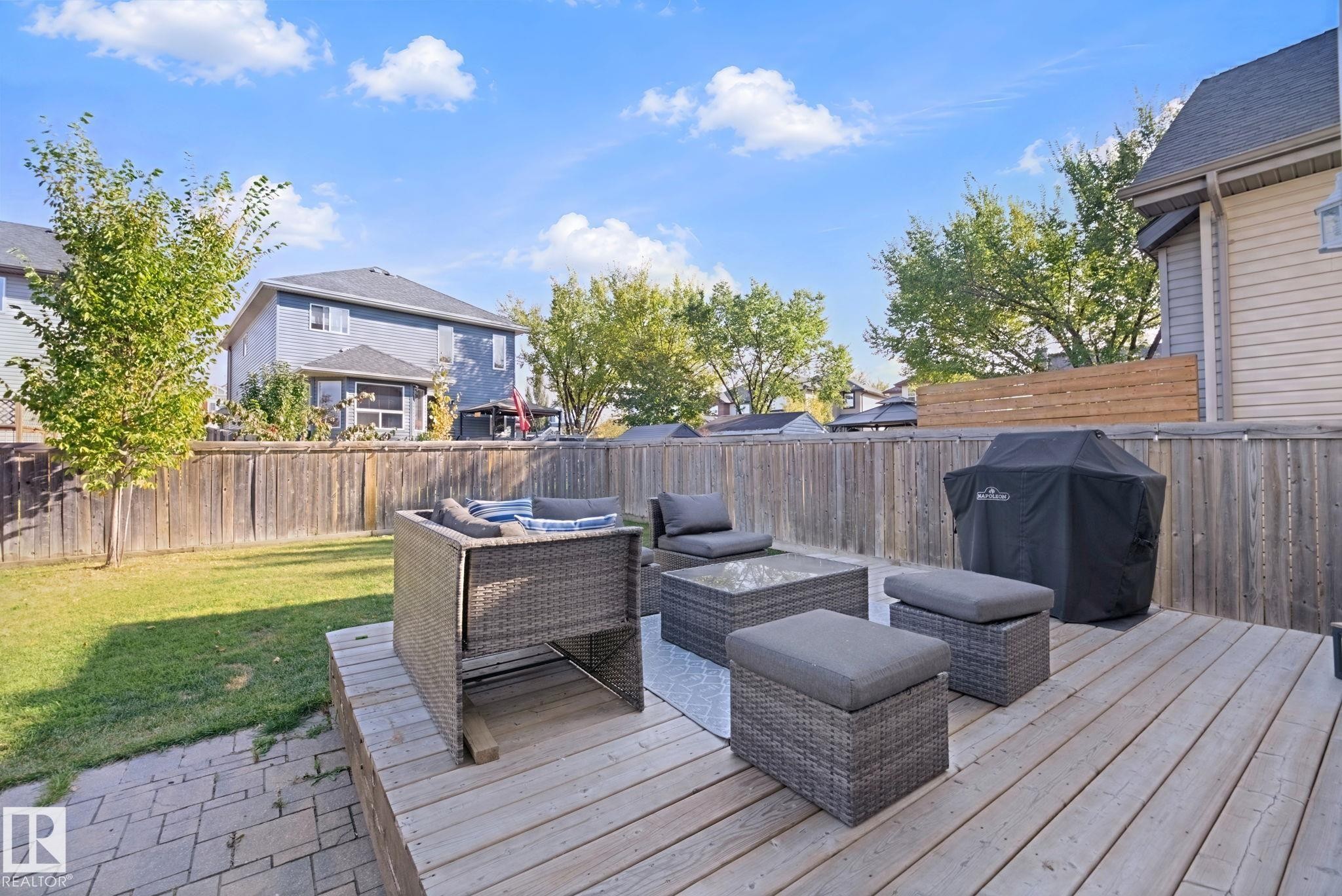 Backyard featuring an expansive wood deck, a partial paver patio, and a manicured lawn area - 324 Ascott Crescent, Sherwood Park, AB