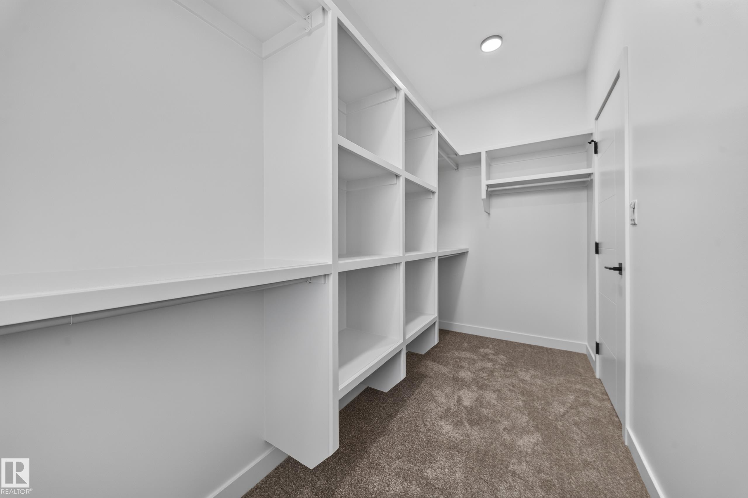 Custom built-in white shelving, integrated hanging rods, recessed ceiling lighting, and carpeted flooring - 13024 186 Avene Nw, Edmonton, AB
