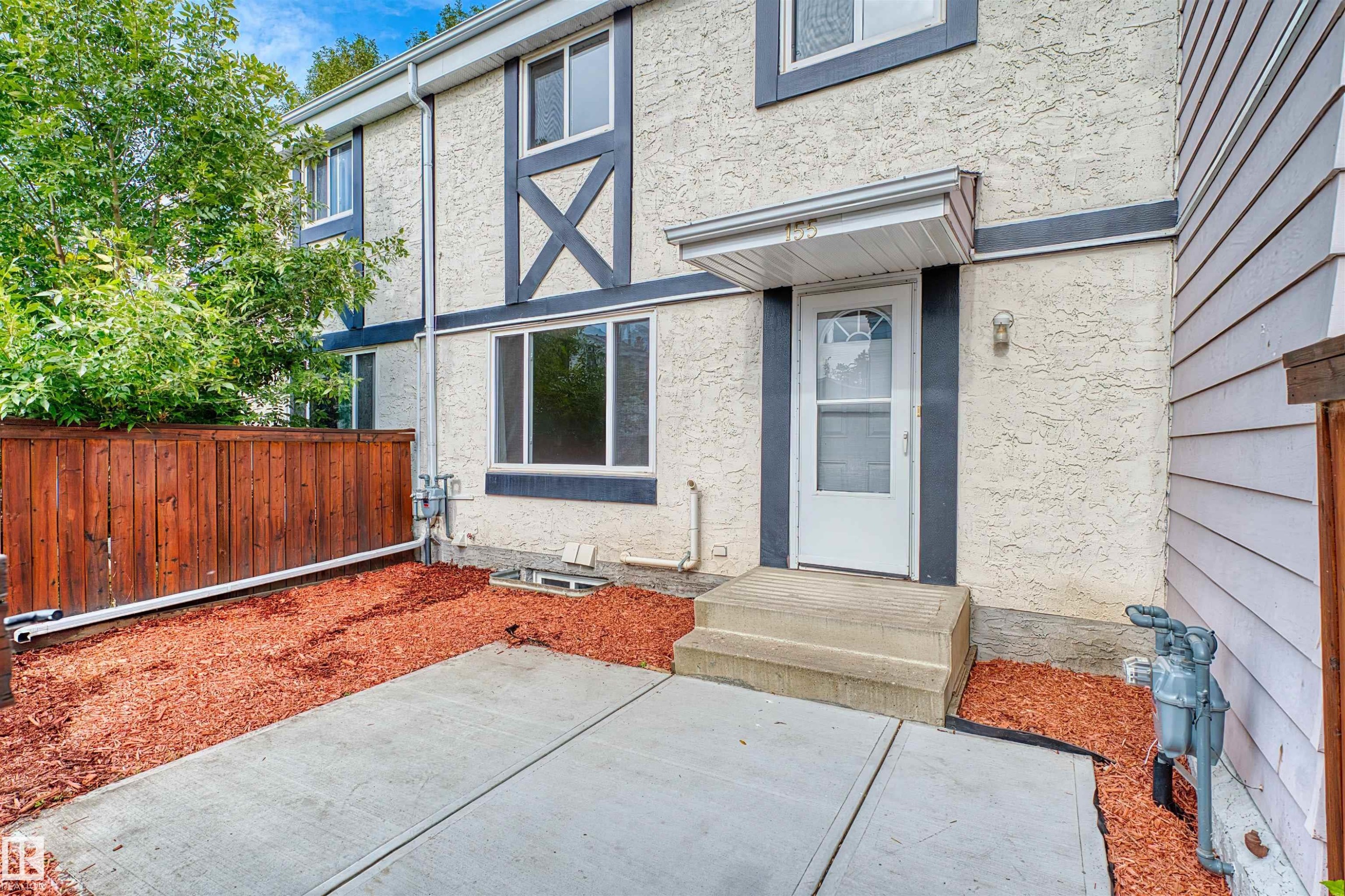 Stucco exterior with decorative trim, concrete steps, and a white entry door with an awning - 155 Primrose Gardens Gardens Nw, Edmonton, AB