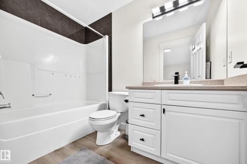 White vanity with black hardware, an undermount sink, and a countertop - #27 287 Macewan Rd Sw, Edmonton, AB 