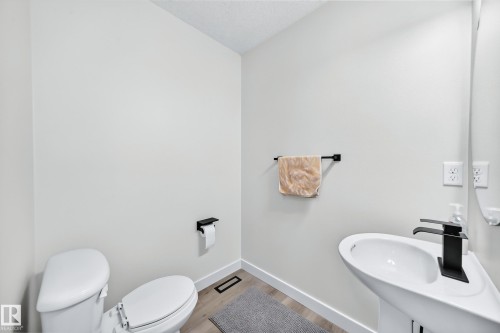 Pedestal sink with matte black faucet and light wood-finish flooring - #27 287 Macewan Rd Sw, Edmonton, AB 