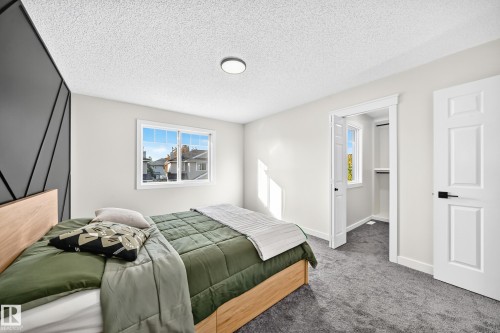 Textured accent wall, neutral wall paint, double-pane window, carpeted flooring, and built-in closet shelving - #27 287 Macewan Rd Sw, Edmonton, AB 