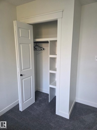 Built-in closet system featuring shelving and hanging rod - #27 287 Macewan Rd Sw, Edmonton, AB 