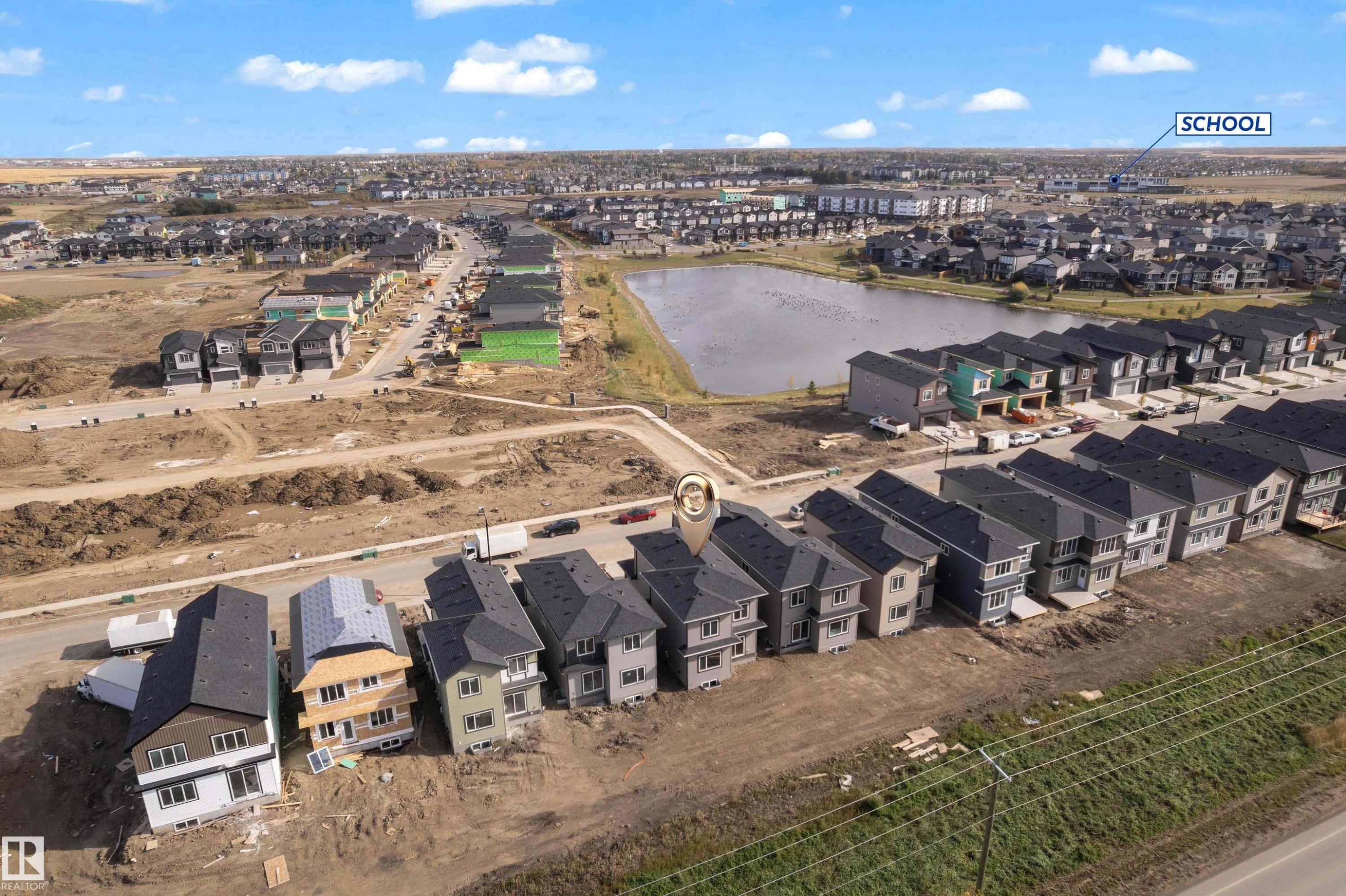 New construction residential development featuring a lake and surrounding properties - 261 Linden Loop, Leduc, AB