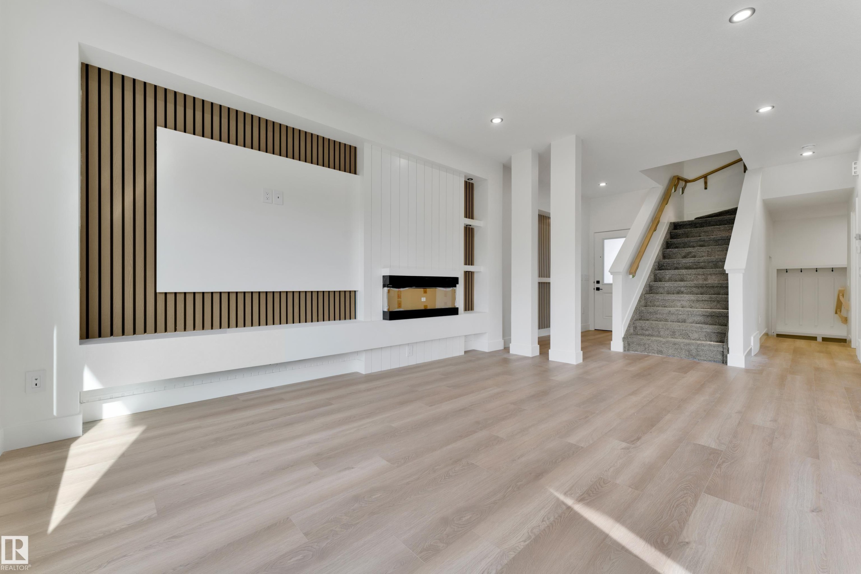 Wood-finish flooring, recessed lighting, and a built-in media console with a fireplace - 261 Linden Loop, Leduc, AB