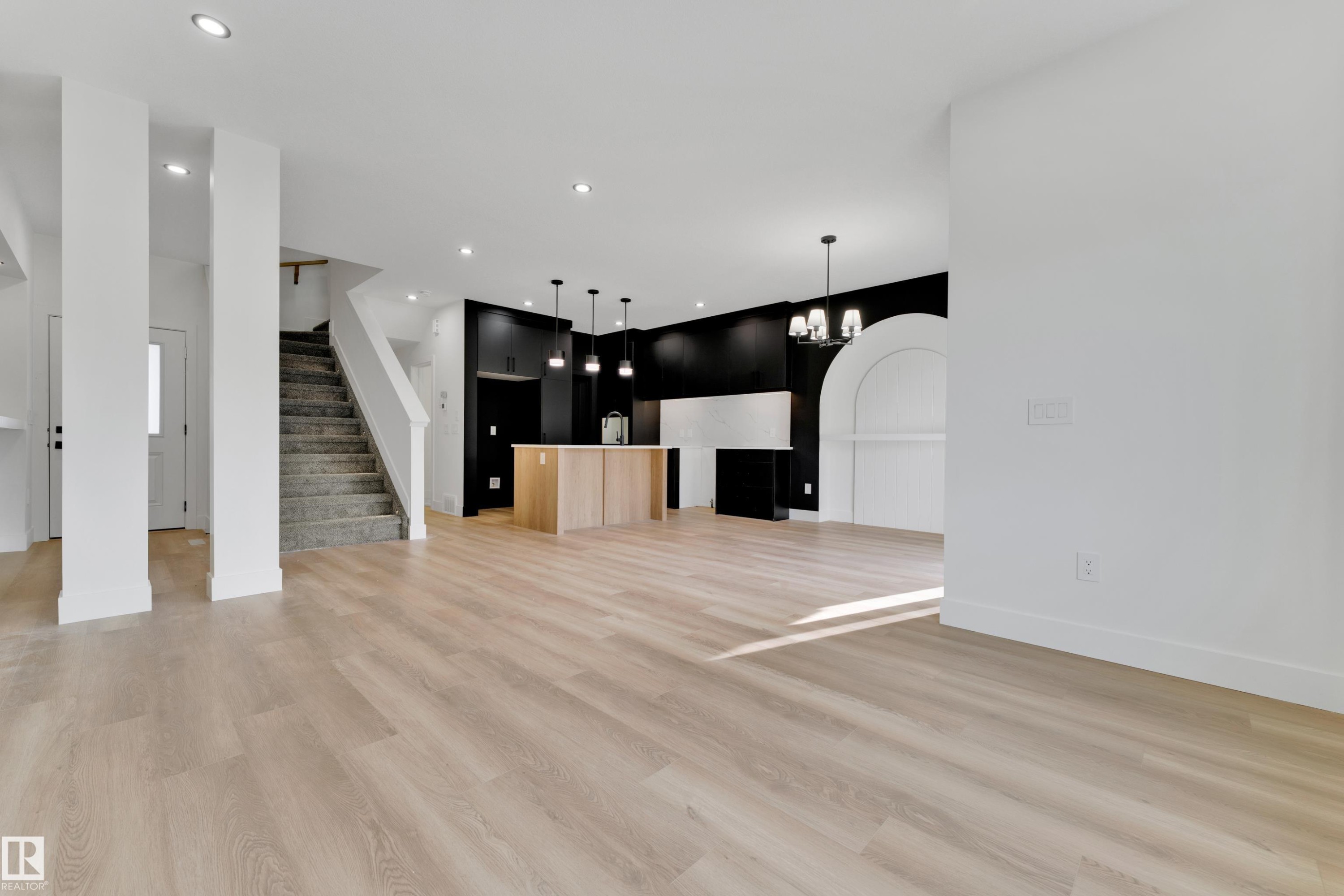 Light wood-finish flooring throughout, recessed lighting, and a staircase with carpeted treads - 261 Linden Loop, Leduc, AB