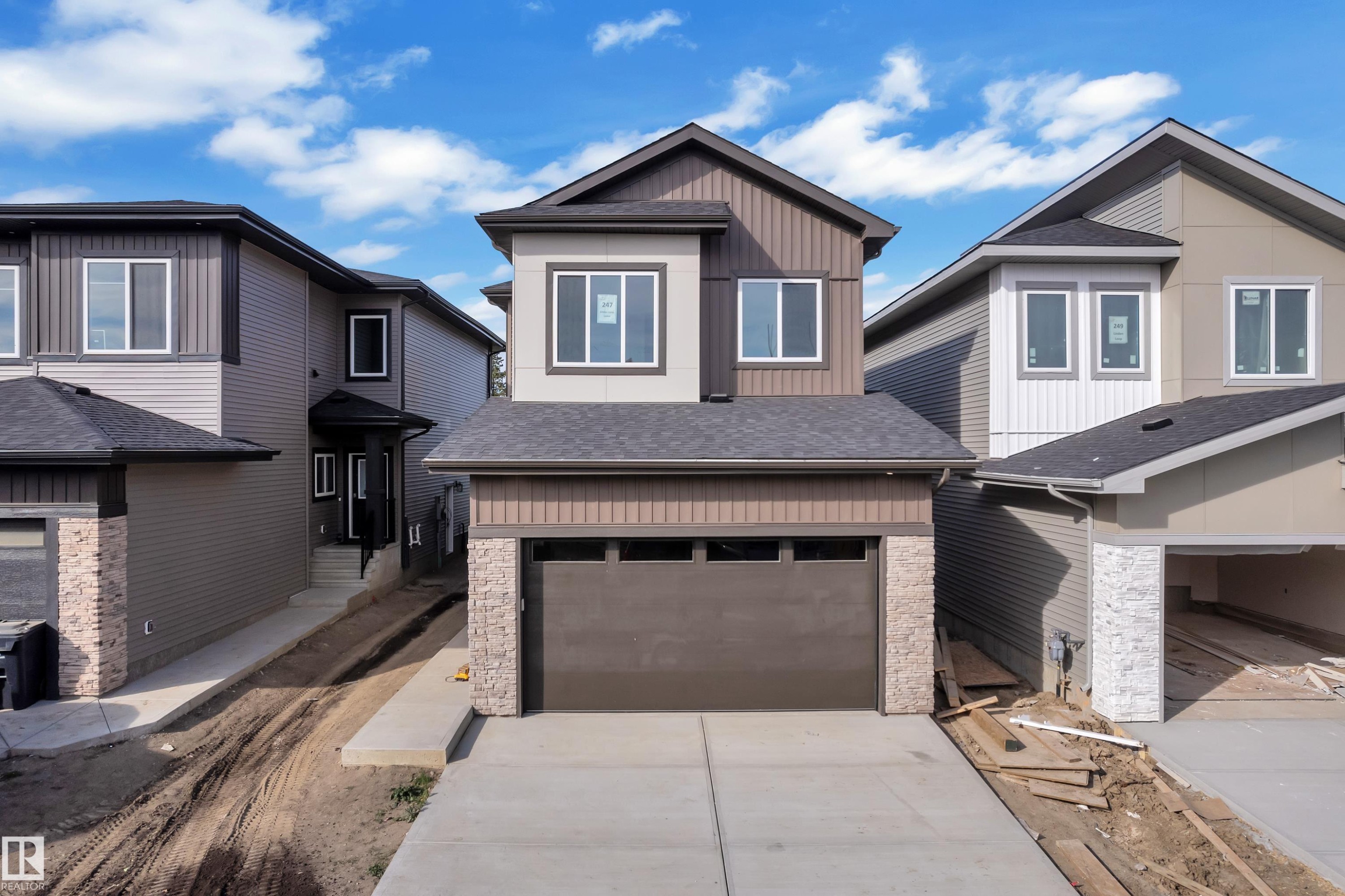 Two-story exterior featuring multi-toned siding, a dark shingle roof, white-framed windows, a single-car garage, and a concrete driveway - 247 Linden Loop, Leduc, AB