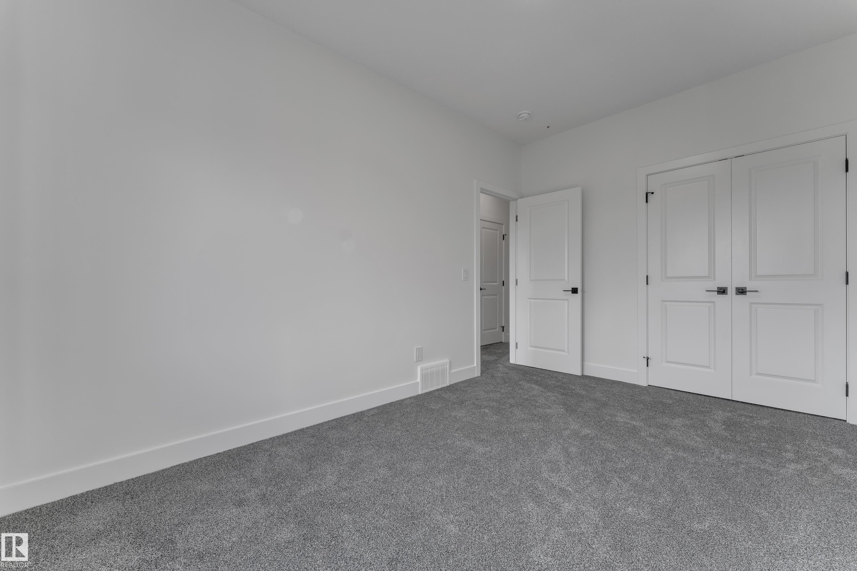 Plush grey carpeting, white interior walls, white trim, and white paneled doors with dark hardware - 247 Linden Loop, Leduc, AB