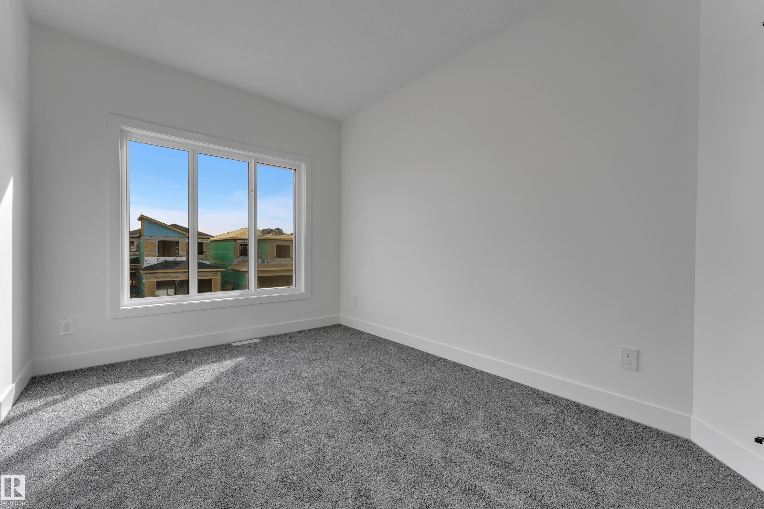 Plush grey carpeting, white painted walls, and a large multi-pane window - 247 Linden Loop, Leduc, AB