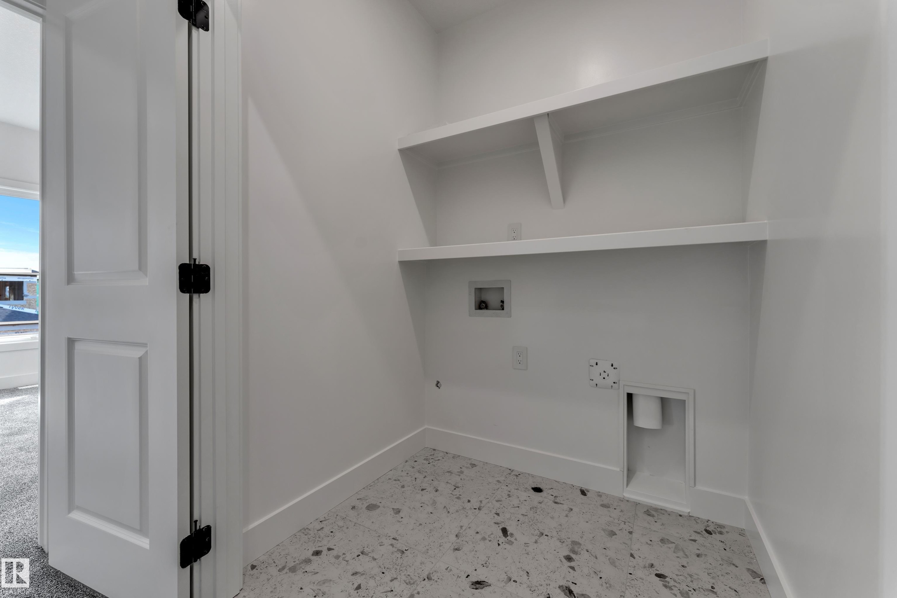 Utility space with built-in shelving, durable flooring, and laundry hookups - 247 Linden Loop, Leduc, AB