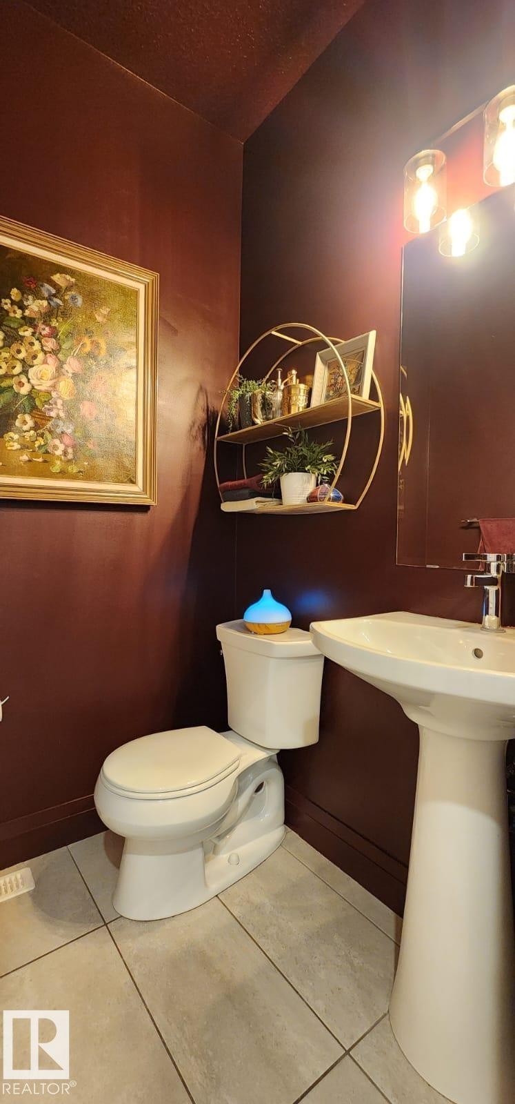 Pedestal sink with chrome faucet, wall-mounted light fixture, and tile flooring - 3779 Cherry Loop Sw, Edmonton, AB