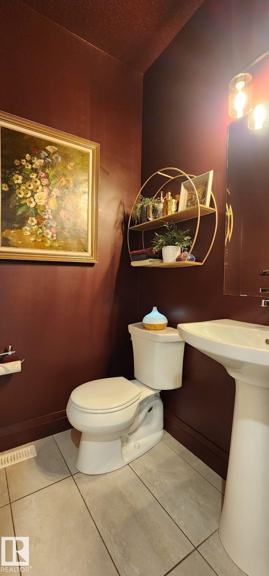 Pedestal sink, wall-mounted light fixture, and floor-set toilet - 3779 Cherry Loop Sw, Edmonton, AB