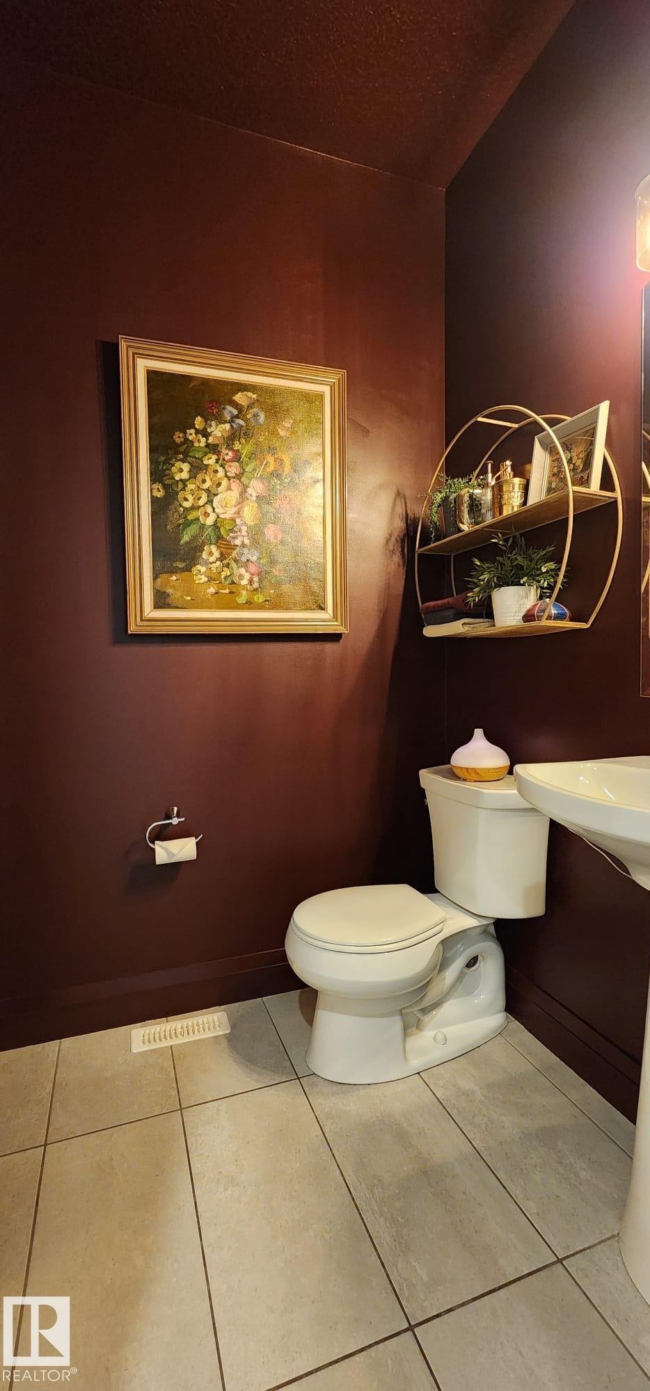 Pedestal sink, wall-mounted toilet paper holder, and a two-tier wall shelf with a gold-finish frame - 3779 Cherry Loop Sw, Edmonton, AB